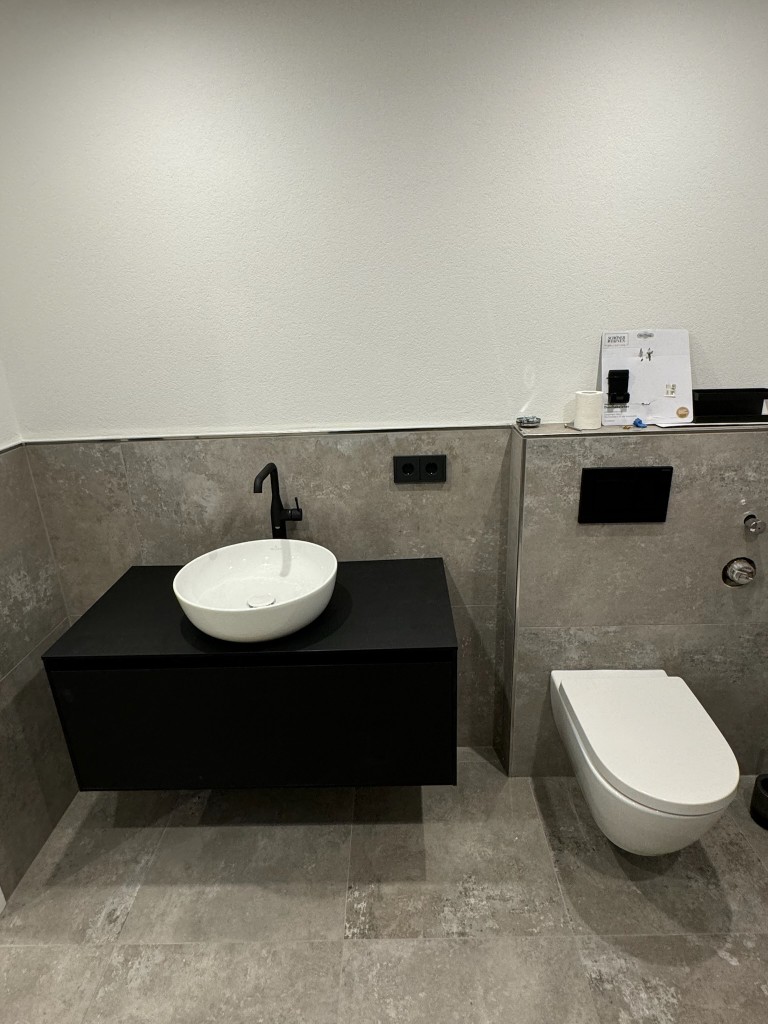 Modernes Bad mit schwarzer Waschtischplatte und wandhängendem WC