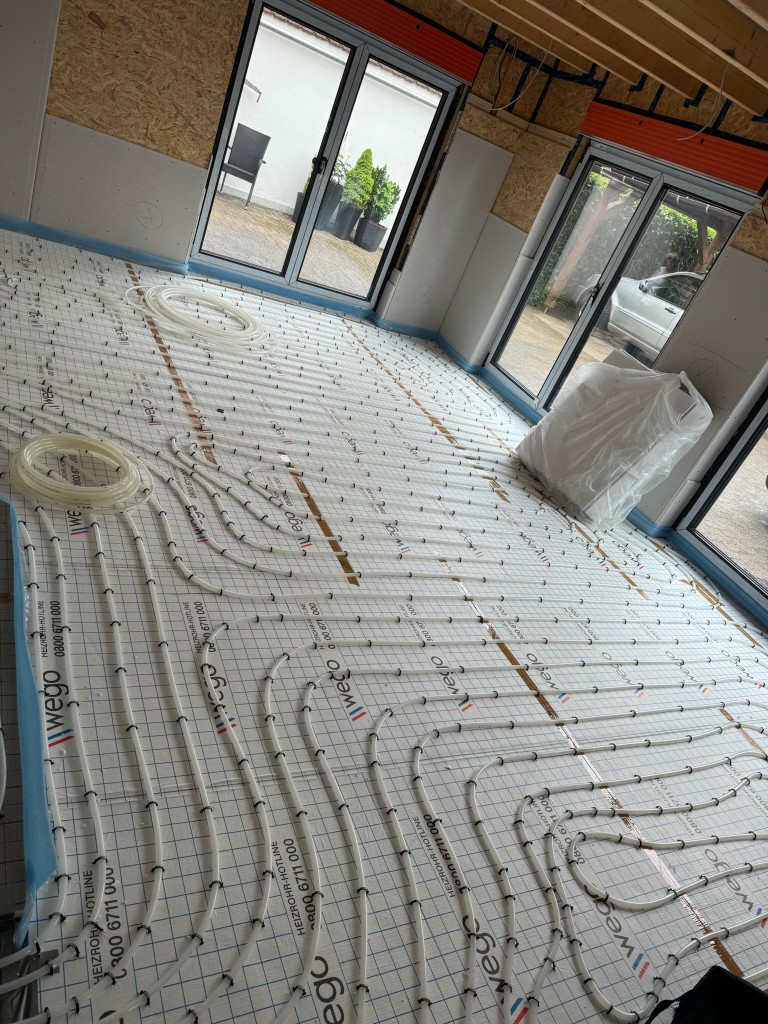 Verlegung einer Fußbodenheizung mit Heizrohren auf Dämmplatten