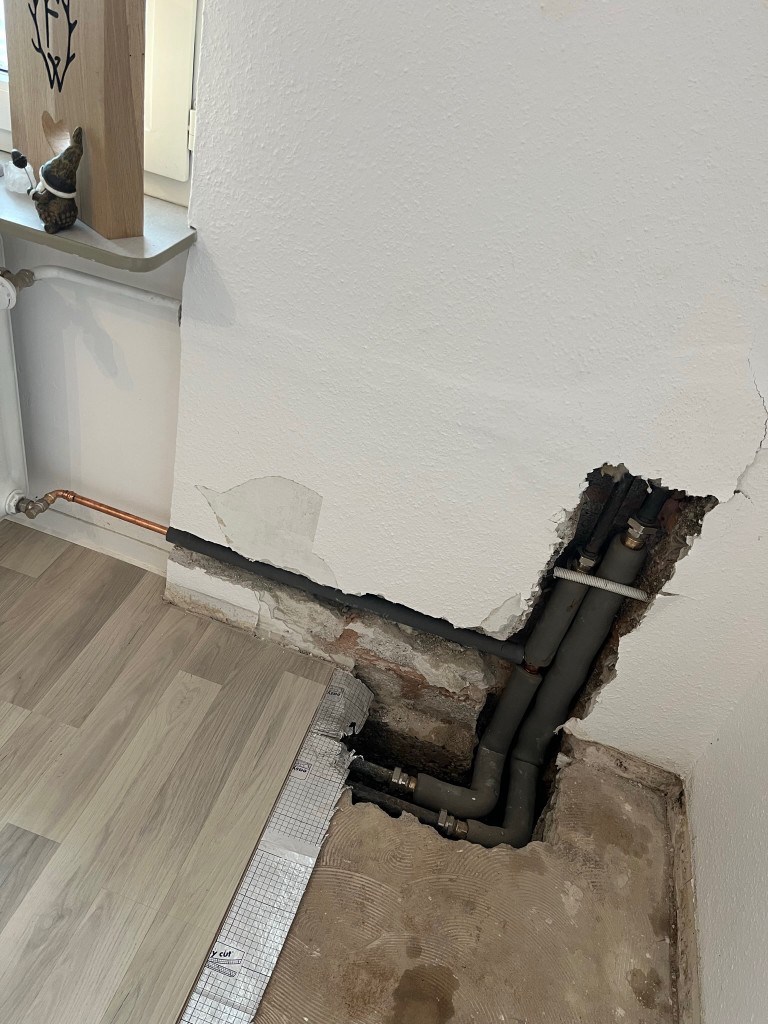 Reparaturarbeiten an Leitungen nach Wasserschaden in Wand und Boden